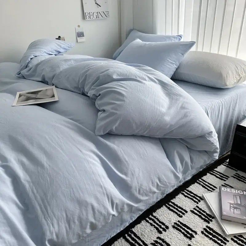 Soft light blue cotton bedding set with slightly wrinkled duvet cover and matching pillows from DecorBites™