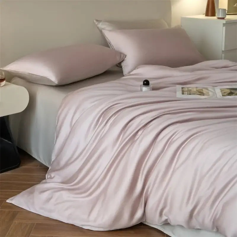 Soft blush pink satin duvet cover set with matching pillowcases featuring a glossy finish for queen or king size beds