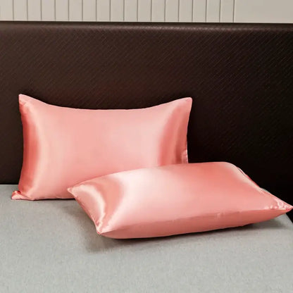 Two blush pink satin pillowcases with a smooth glossy finish from decorbites luxurious solid color bedding set