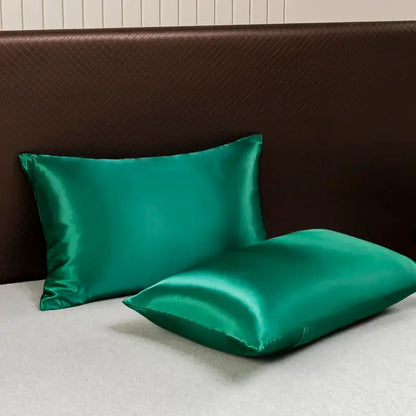 Two emerald green satin pillowcases with a glossy finish from the decorbites luxurious solid color bedding set