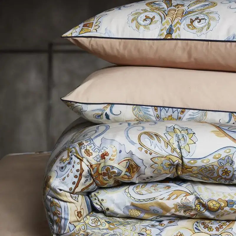 Stacked pillows and duvet cover in ornate paisley cream gold blue tones in DecorBites™ luxury Egyptian cotton bedding set pieces pillowcases 48*74cm