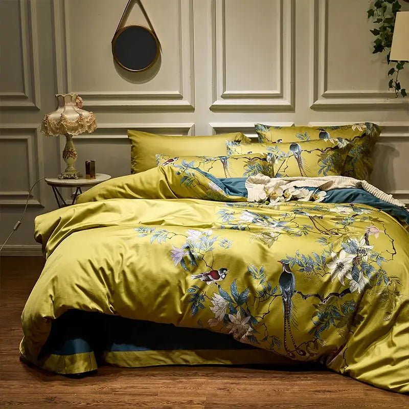 Vibrant yellow satin duvet cover and pillowcases with intricate bird and floral embroidery in egyptian cotton
