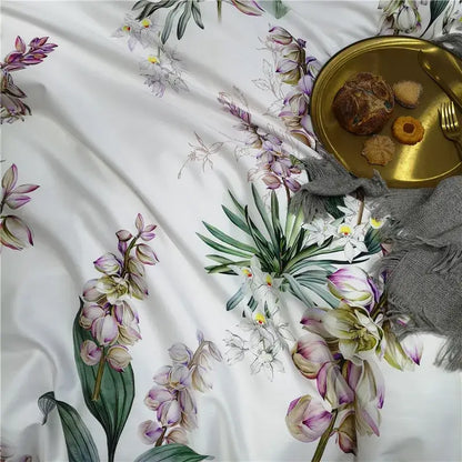 White satin duvet cover and pieces pillowcases with delicate botanical prints in soft purples greens and whites by decorbites
