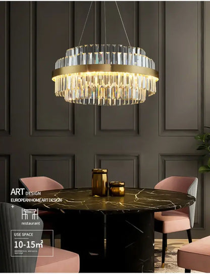 Gold-toned decorbites™ luxury led crystal chandelier with cascading prisms above dark marble dining table