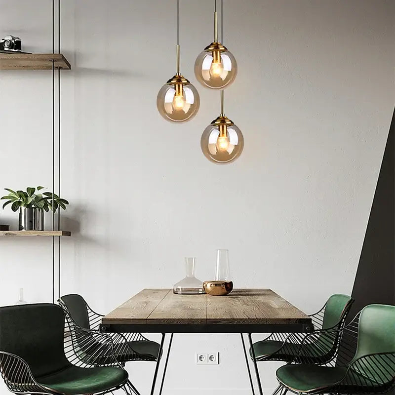 DecorBites luxury nordic led chandelier with three glass shades and brass fixtures above a wooden dining room table