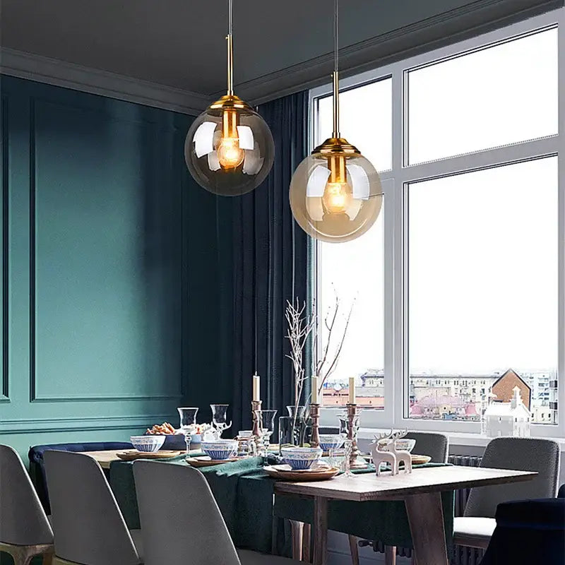 Two modern pendant lights with gold metal fixtures and smoked glass shades in a luxury nordic led chandelier for dining room