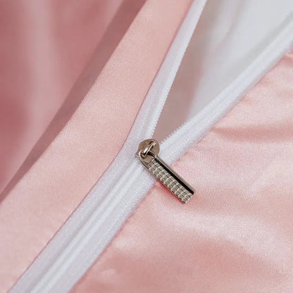 A silver-toned zipper pull with a textured pattern on the decorbites™ luxury solid color pcduvet cover in soft pink satin