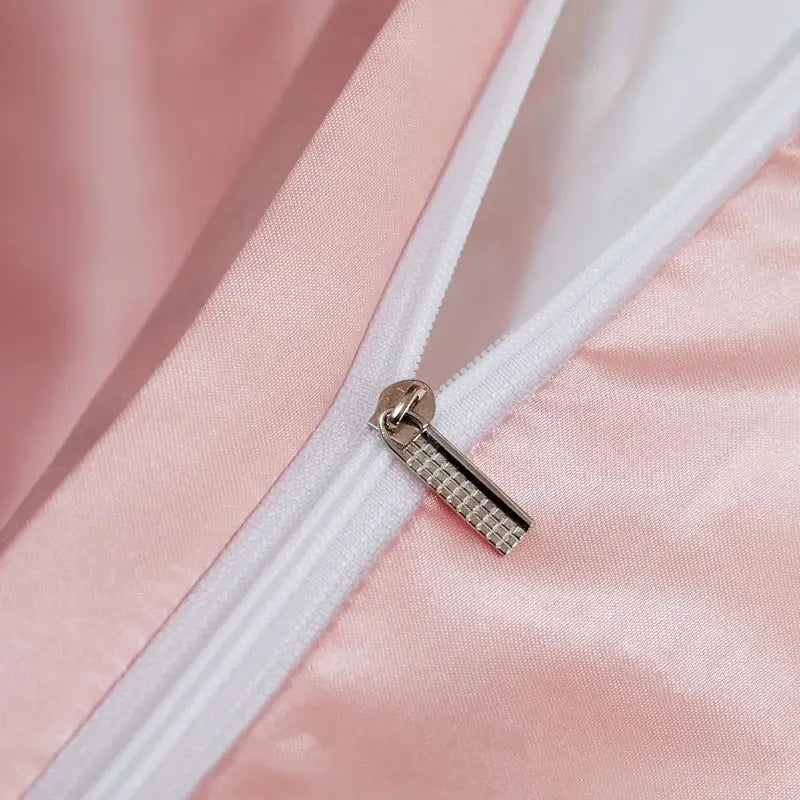 A silver-toned zipper pull with a textured pattern on pink satin in the decorbites luxury bedding set for width bed pcduvet cover