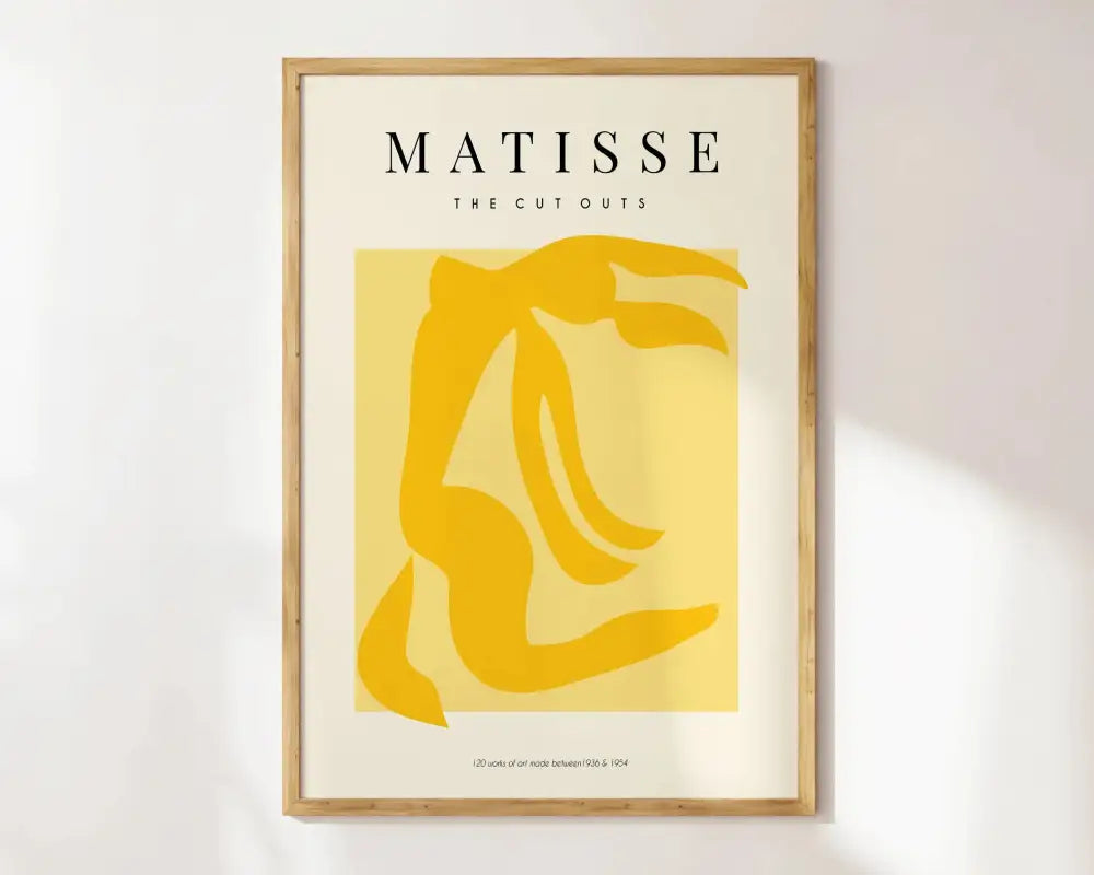 A minimalist decorbites matisse floral art print with bold yellow cutout on cream in a light wood frame