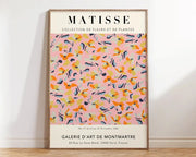 A framed canvas print featuring a vibrant matisse flower poster with orange and blue floral patterns on a soft pink background