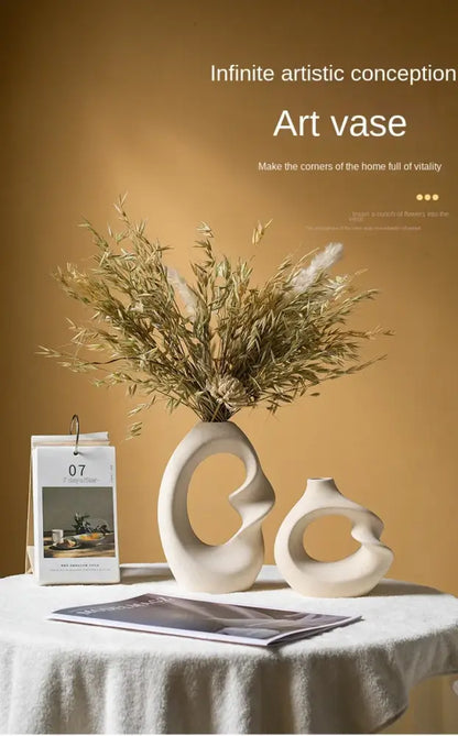 Cream-colored matte ceramic vase set with abstract flowing curves and central opening for modern home decor