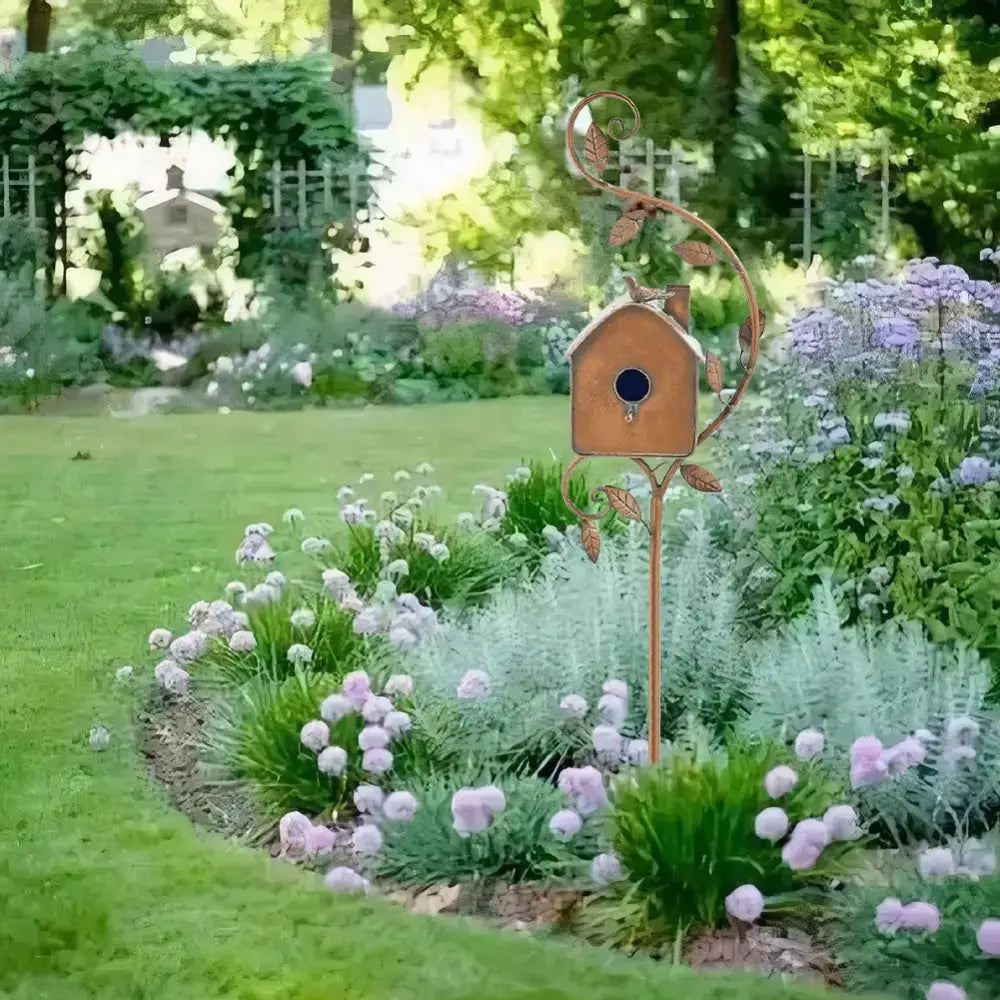 Rustic bronze metal birdhouse garden stakes with leafy vine design and dark blue circular entrance for outdoor decor