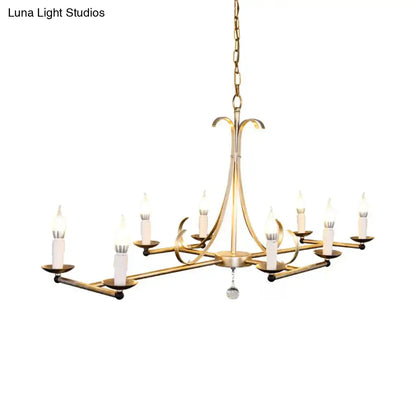 Gold-toned metal island chandelier with eight traditional candle bulbs and a dangling crystal accent