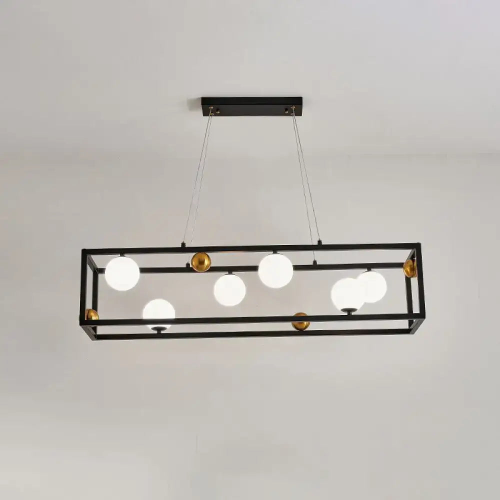 Black rectangular metal pendant light with gold accents and milk glass shade for industrial dining rooms