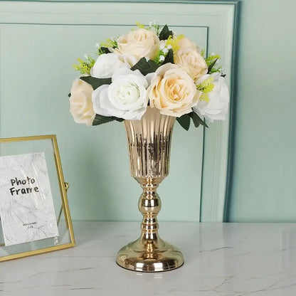 DecorBites metal trumpet vase in gold metallic fluted design holding cream white artificial roses with green leaves