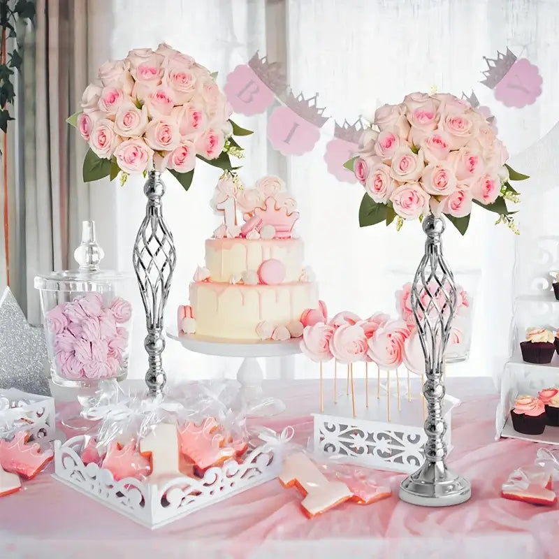 A two-tiered birthday cake with creamy white and pale pink drip design beside a decorbites metal vase set for special occasions