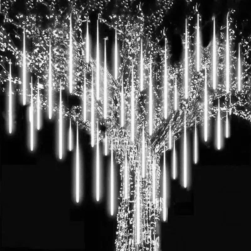 White led meteor shower string lights hanging from a tree for outdoor decor by DecorBites™