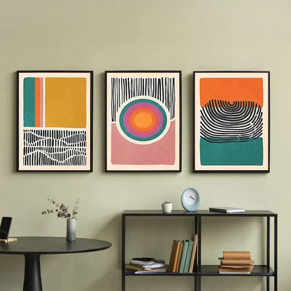 Three framed DecorBites™ mid century abstract color block wall art set prints with bold geometric patterns on green wall