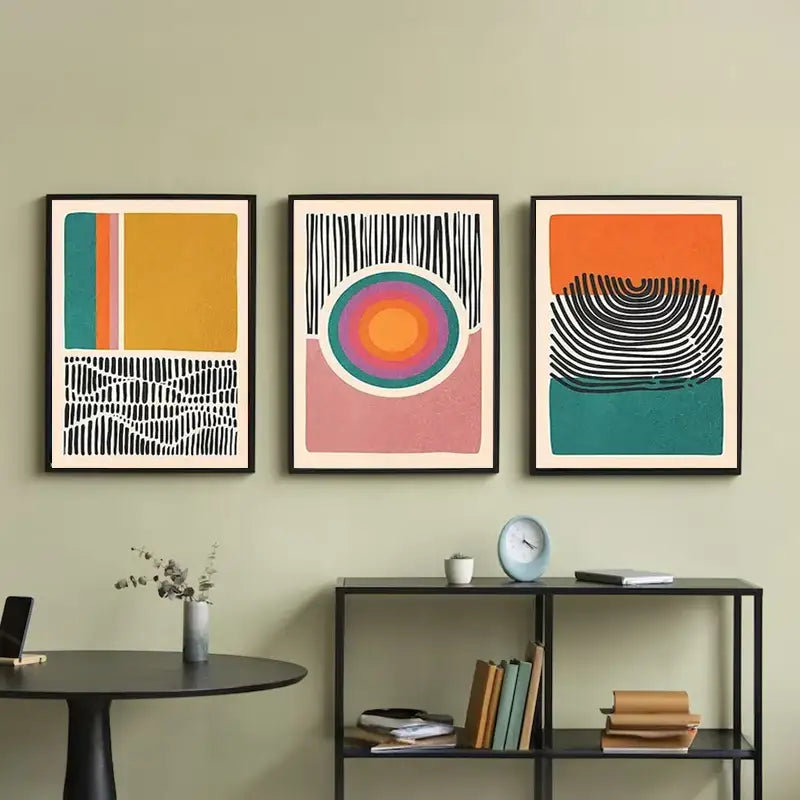 Three framed DecorBites™ mid century abstract color block wall art set prints with bold geometric patterns on green wall