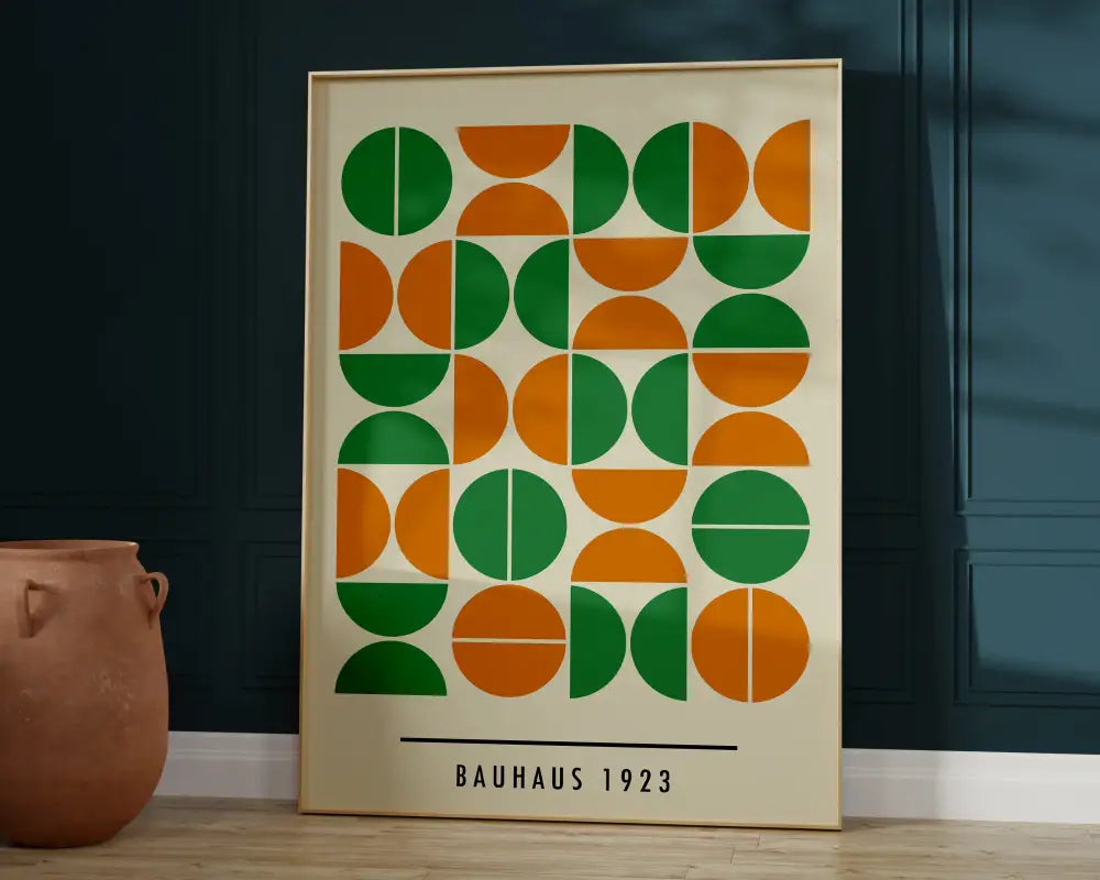 A framed mid century bauhaus wall art canvas featuring green and orange geometric half circles on off-white background