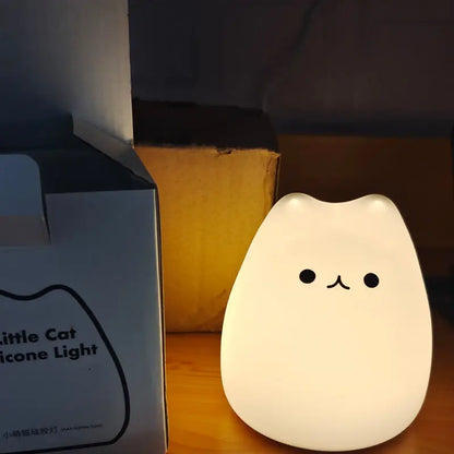 A soft white silicone mini popular cat night lamp with a smiling face and power switch for bedside use