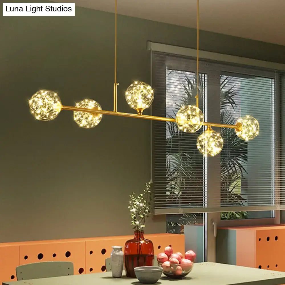 Gold-toned DecorBites™ minimalist LED pendant ceiling light with five glowing clear glass sphere shades suspended by rods