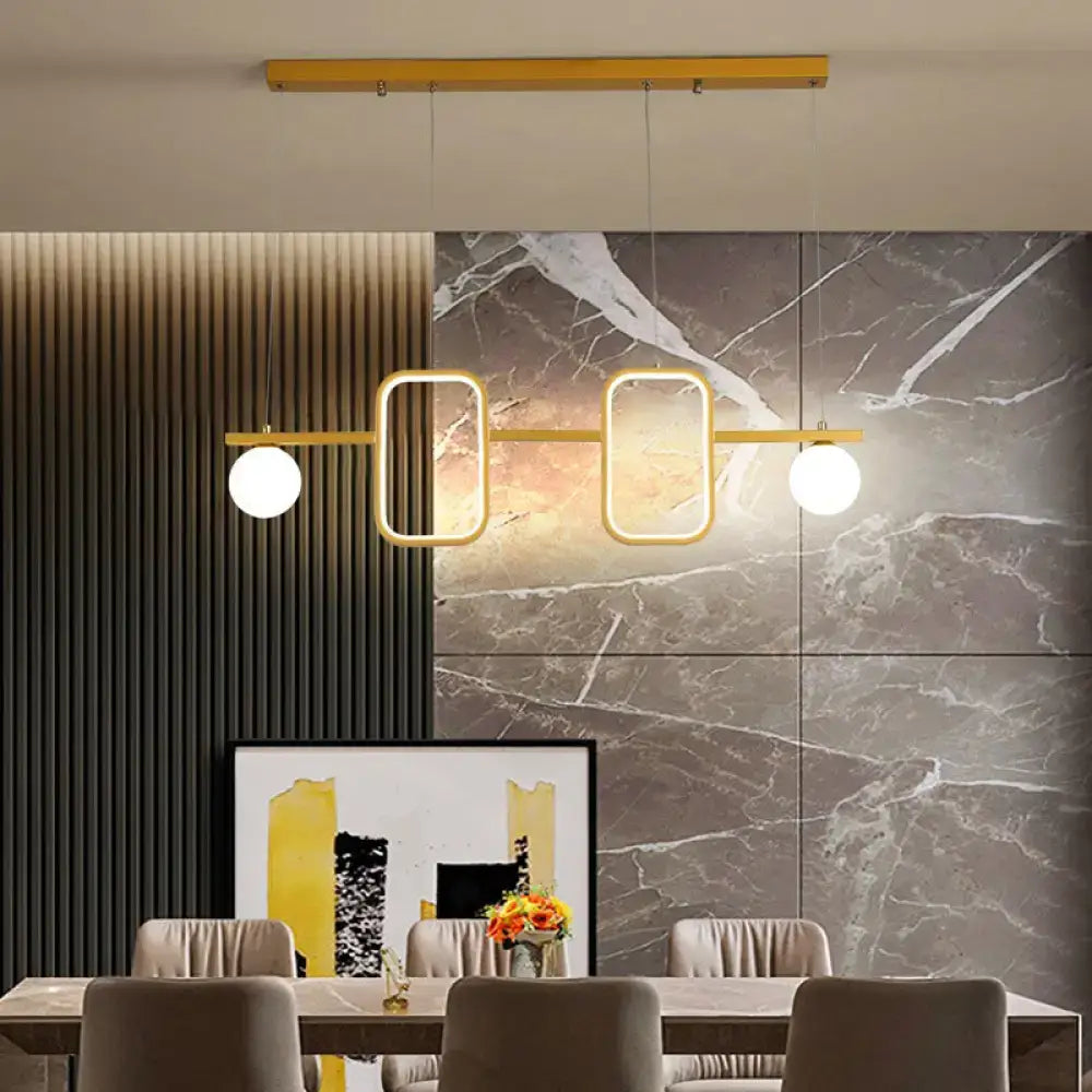 Modern gold-toned decorbites pendant light with symmetrical geometric led design and cream glass shade for dining rooms