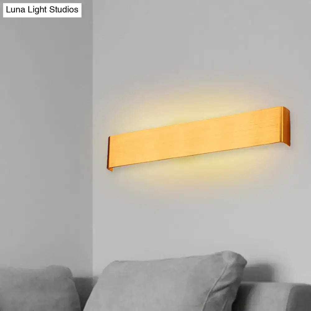 Gold-finished rectangular wall lamp with sleek modern design providing warm white light for living room ambiance
