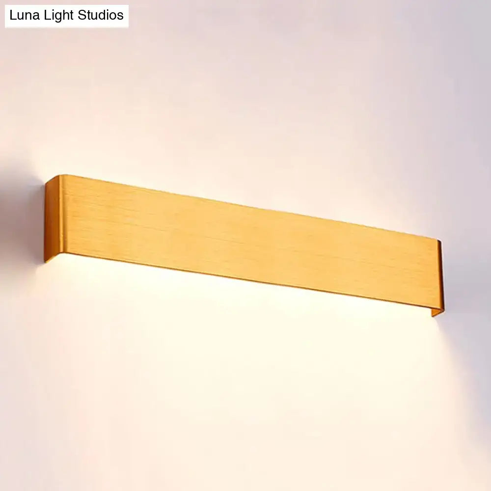 Modern gold-finished rectangular wall lamp with minimalist design providing warm white light for living room use