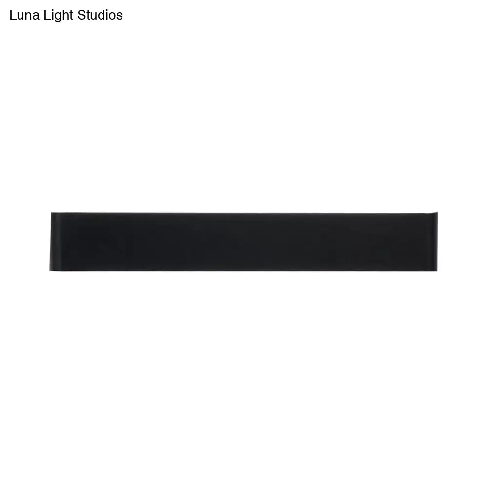 Minimalist black rectangular wall lamp with smooth matte finish and silver accents for warm white living room lighting