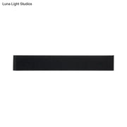 Minimalist black rectangular wall lamp with smooth matte finish and silver accents for warm white living room lighting