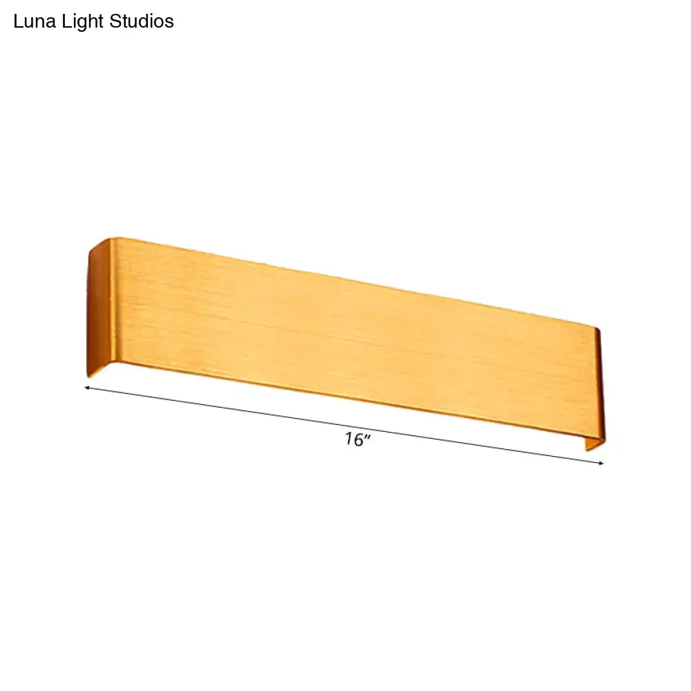 A sleek brushed gold 16-inch rectangular wall lamp with warm white light for minimalist living room decor