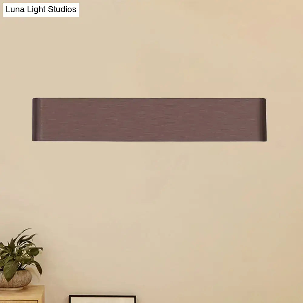 Modern matte bronze rectangular wall lamp with minimalist design providing warm white light for living room use