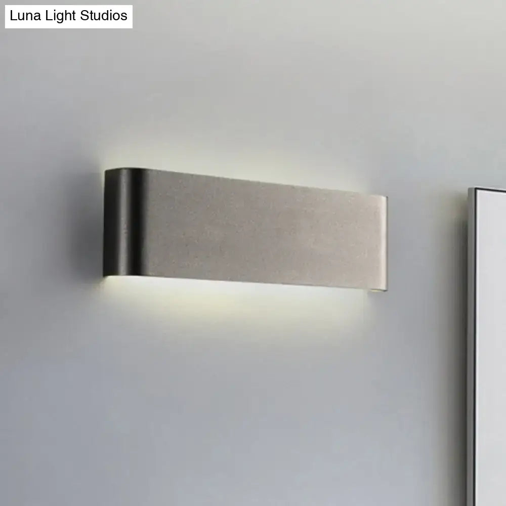 Modern brushed stainless steel wall lamp with sleek rectangular design providing warm white light for living room use
