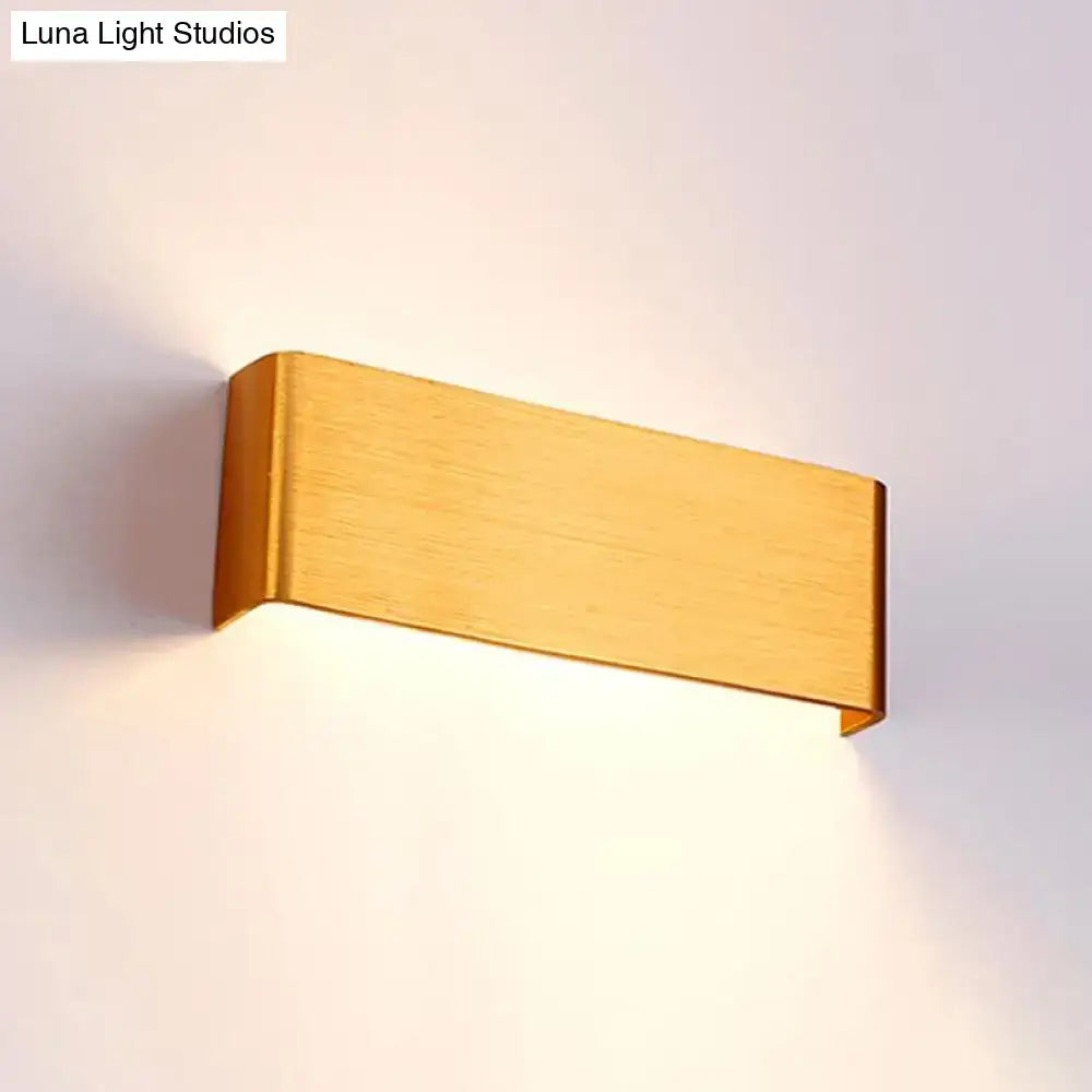 Gold-finished rectangular wall lamp with sleek minimalist design providing warm white light for living room use