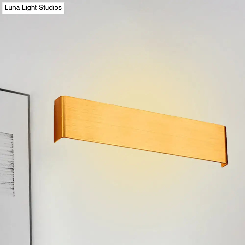 Gold-finished rectangular wall lamp with sleek modern design providing warm white light for living room use