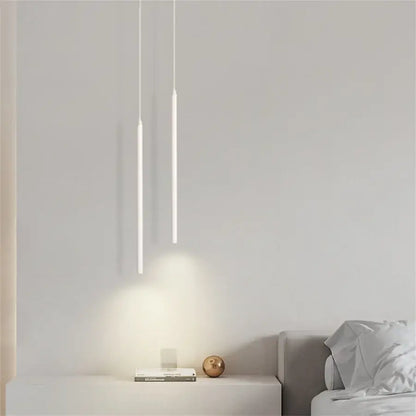 Two minimalist white DecorBites™ modern 2cm led pendant lights hang vertically casting soft glow on kitchen island wall