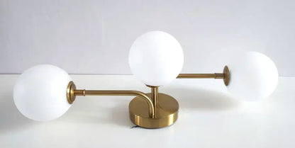 Gold-toned table lamp with three frosted acrylic ball shades in a modern branching design for stylish ceiling light use