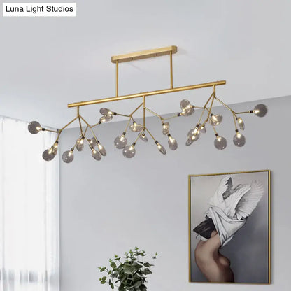 Gold-toned modern firefly island pendant with branching arms and clear glass globe bulbs for dining room lighting