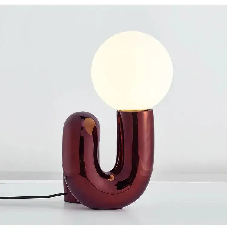 Decorbites™ modern art table lamp with a sleek burgundy ceramic base and glowing spherical bulb for stylish lighting