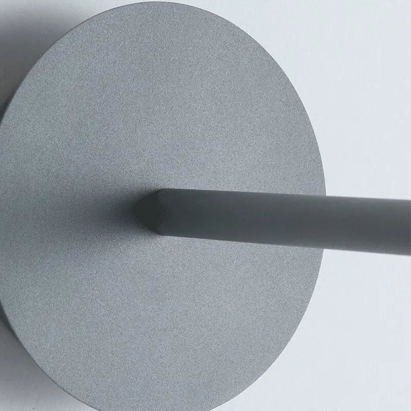 Gray matte-finished circular wall light with a sleek cylindrical stem from DecorBites™ modern bedside wall light