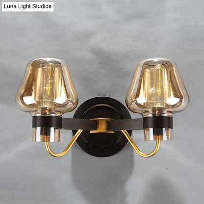 Modern black and gold amber glass mushroom sconce light fixture with double-light amber glass shades and black metal base