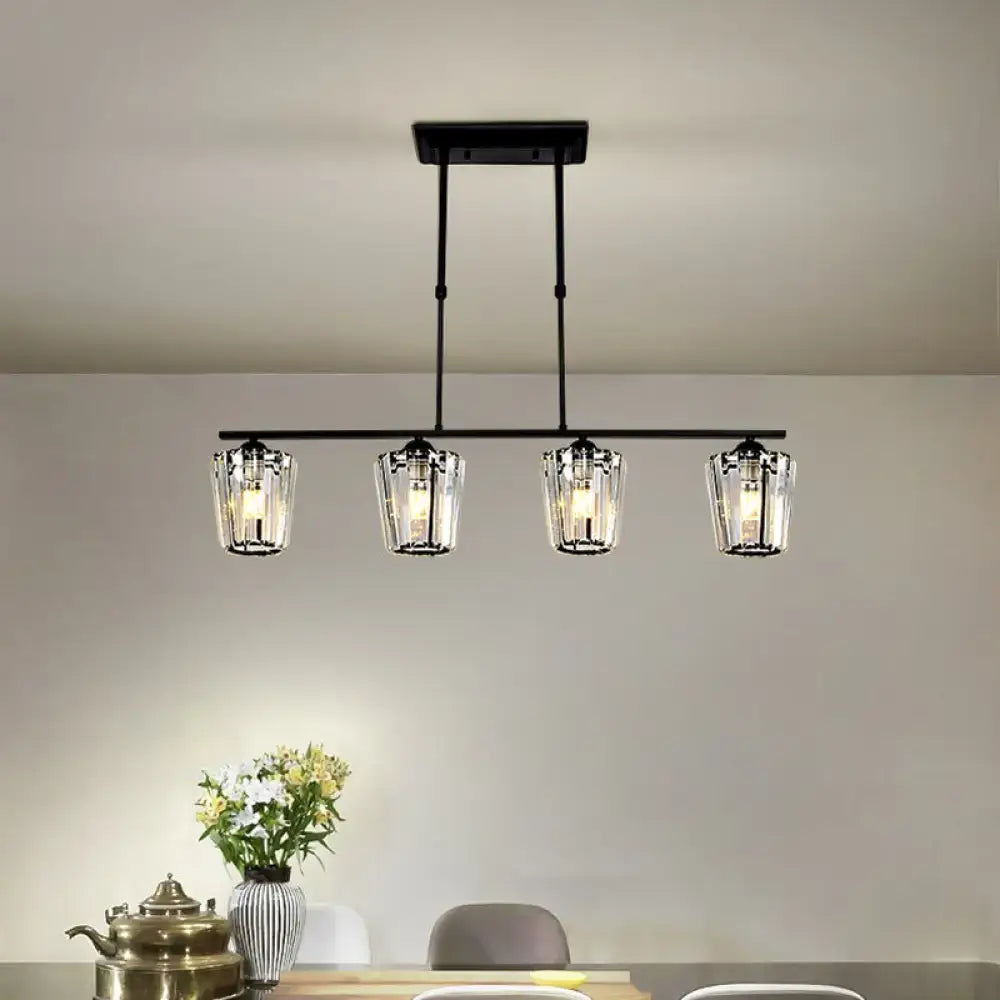 Black metal island chandelier with four clear glass candle-style shades and cylindrical crystal shade design