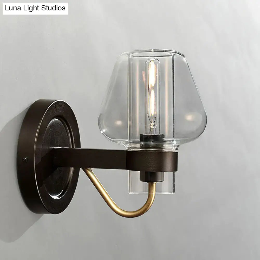 Modern black and brass wall sconce with glass mushroom shade featuring a dark bronze base and exposed filament bulb