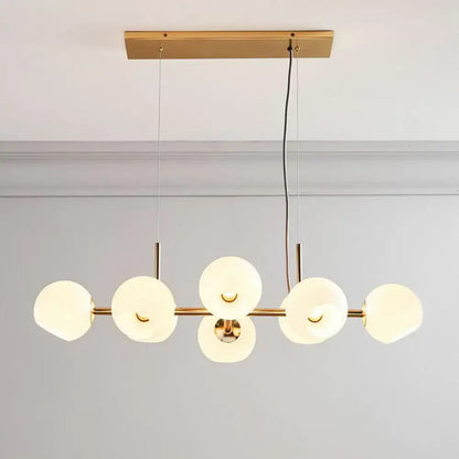 Decorbites modern brass dining room suspension light with six frosted glass orbs in a linear design