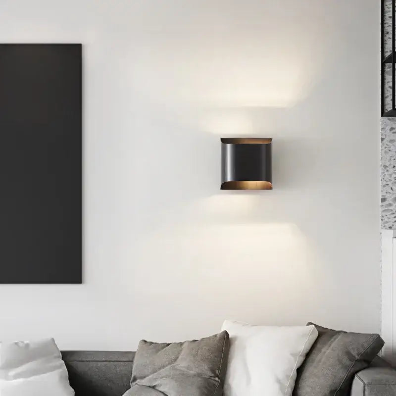 Black cylindrical decorbites wall lamp with warm glowing light and modern brass led accents for stylish interior lighting