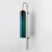 Decorbites modern brass wall sconce with a tall pine green glass shade on slender brass rods and arched top
