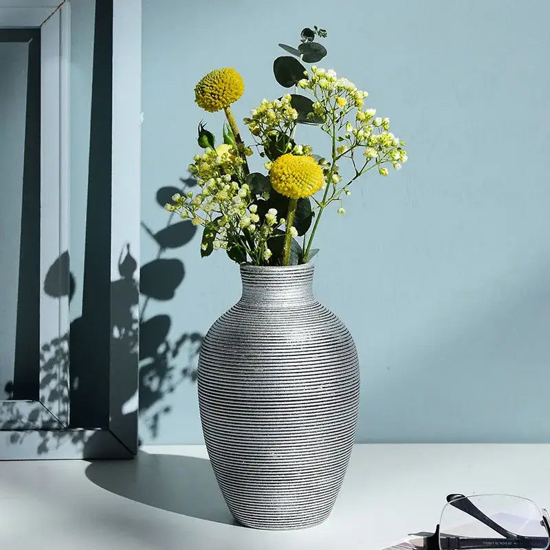 Silver ribbed ceramic nordic vase holding yellow and white flowers for modern home decor by DecorBites™