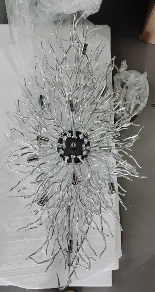 Silver metallic modern crystal chandelier with intricate branching arms and black central hub for living room decor