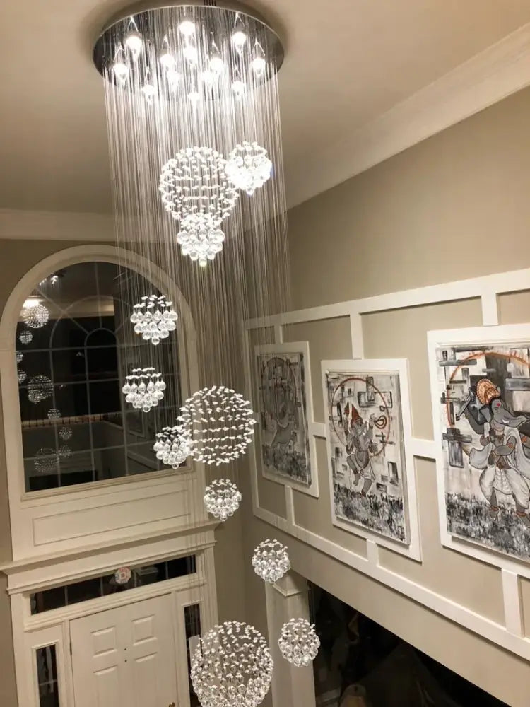 Decorbites modern crystal raindrop chandelier with 13 led bulbs featuring cascading crystal strands for high ceiling spaces